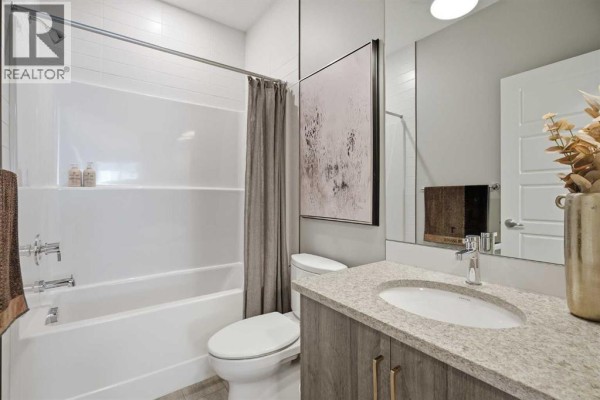 A home office with grey walls, a desk, office chair, and a large window. - 468 Dawson Circle, Chestermere