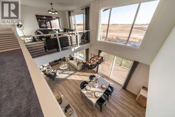 View from the second-floor hallway of the living room, dining room, and backyard. - 468 Northern Lights Place, Langdon