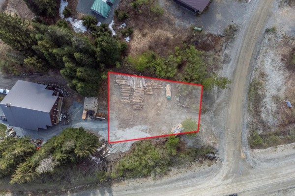 Aerial view of a cleared lot with lumber stacked and outlined in red, surrounded by trees and gravel roads. - 46930 Sakwi Creek Road, Agassiz