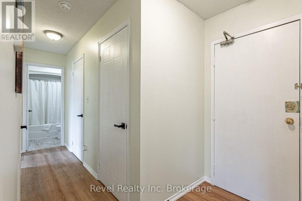 Interior hallway with light wood laminate flooring, white doors, and access to a bathroom. - 47 - 56 Hiawatha Road, Woodstock