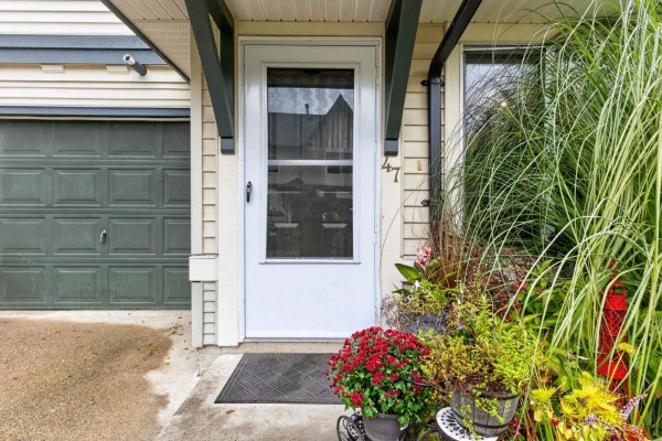 Close-up of the front door of a townhouse with potted plants and house number 47. - 47 18883 65 Street, Surrey