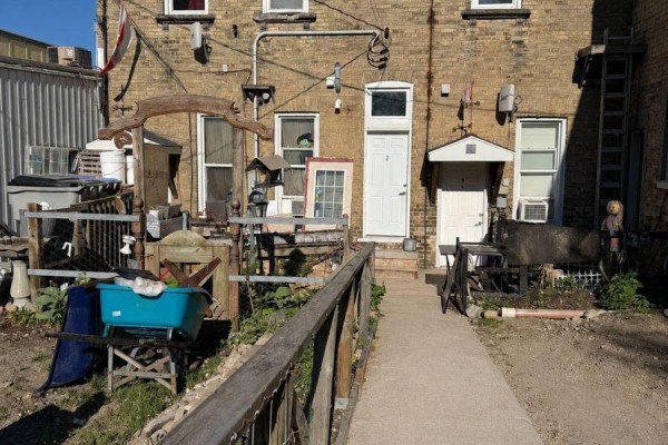Rear exterior of building with several doors, windows, and assorted items stored in yard. - 47 Albert Street, Central Huron