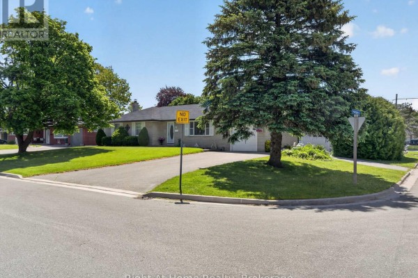 Street view of the house from a corner, showing a large tree and sign. - 47 Churchill Avenue, Oshawa