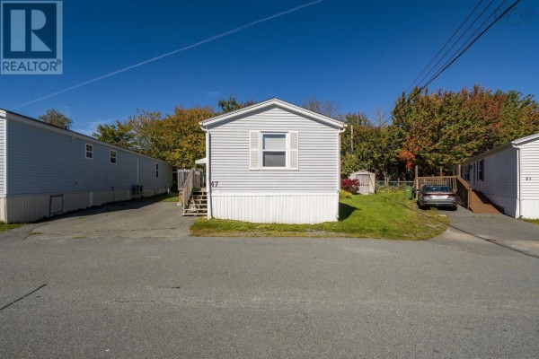 Wooden deck with grills and outdoor seating, extending from the side of the mobile home. - 47 Earleton Avenue, Dartmouth