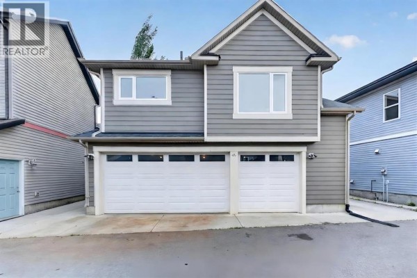 Rear exterior of a grey vinyl-sided house with a two-car garage and multiple windows. - 47 Elgin Meadows Road Se, Calgary