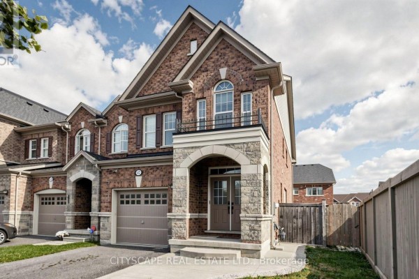 Front exterior of a brick townhouse with a covered entrance and an attached garage. - 47 Goodsway Trail, Brampton
