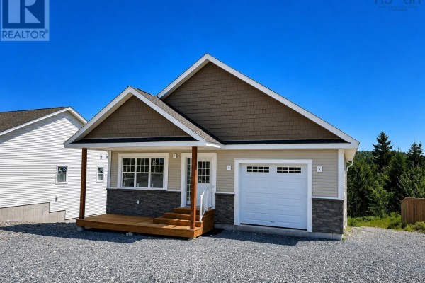 Side exterior view of the beige house, showing a garage and wooden porch with stairs. - 47 Gosling Circle, Porters Lake