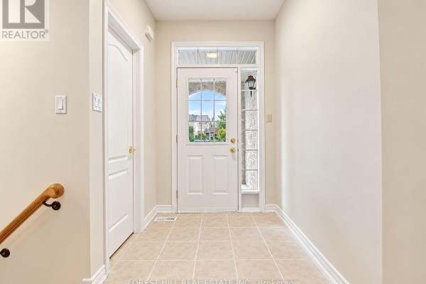 Interior foyer with beige walls, tiled flooring, and a white front door with glass panels. - 47 Loire Valley Avenue, Vaughan