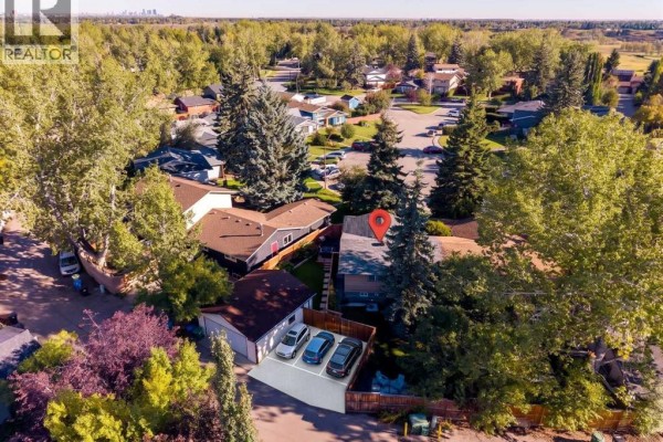 Aerial view of the duplex with a detached garage and parking pad. - 47 Midvalley Rise Se, Calgary