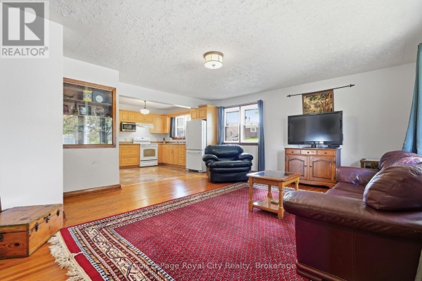 Living room with leather sofas, a TV, and an open view to the kitchen. - 470 Dublin Street, Wellington North