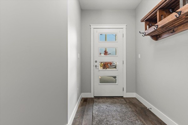 Interior view of a narrow entryway with a white door and wood-look flooring. - 470 Fort Street, Hope, Hope