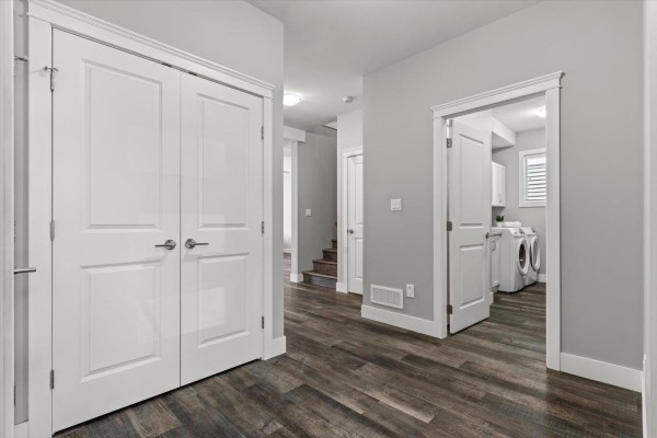 Interior hallway with double white doors, stairs, and a laundry room entrance. - 470 Fort Street, Hope, Hope