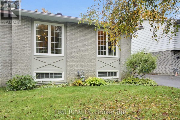 Close-up of the light grey brick exterior with large multi-paned windows and decorative panels. - 470 Joseph Street, Carleton Place
