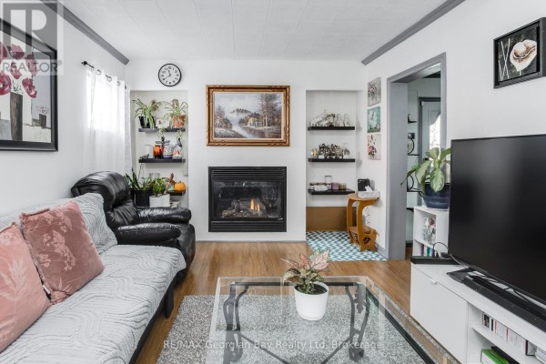 Living room with fireplace, built-in shelves, sofa, and TV - 470 Manly Street Midland