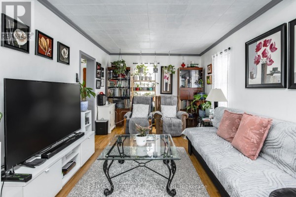 Living room with sofa, armchairs, TV, coffee table, and bookshelves - 470 Manly Street Midland