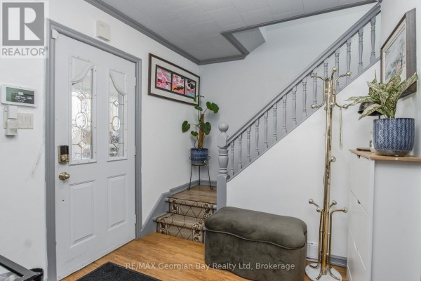 Double front door, staircase, coat rack, and ottoman in hallway - 470 Manly Street Midland