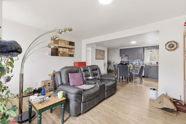 Living room with leather couches, a dining area, and a gray kitchen in the background. - 470 Rue Des Pins, Gatineau