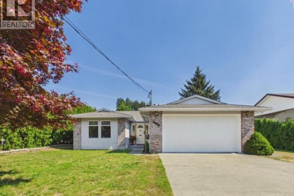 Close-up of the white garage door and concrete driveway of the light blue house. - 4706 Ontario Ave, Powell River