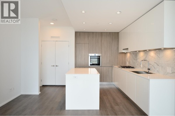 Modern kitchen with white and wood cabinetry, stainless steel appliances, and an island. - 4708 4650 Brentwood Drive, Burnaby