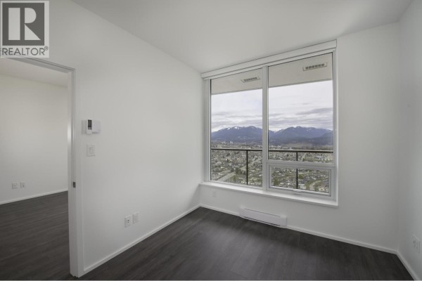 Bedroom with a large window offering a view of the city and mountains. - 4708 4650 Brentwood Drive, Burnaby