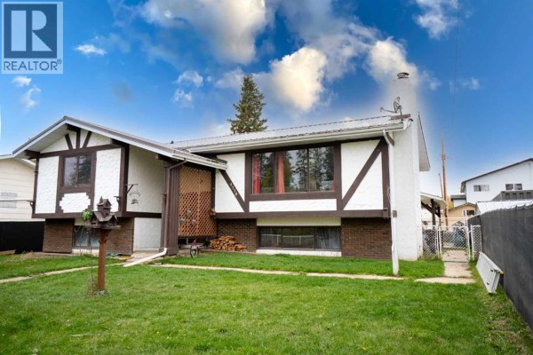 Side view of a two-story house with white stucco and dark brown trim. - 4716 49 Street, Caroline