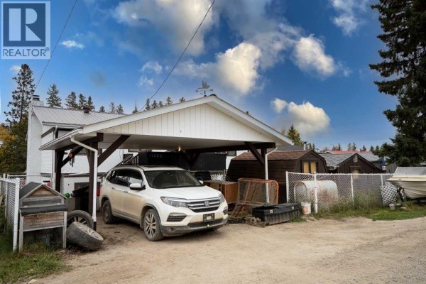White carport with a light-colored SUV parked underneath. - 4716 49 Street, Caroline