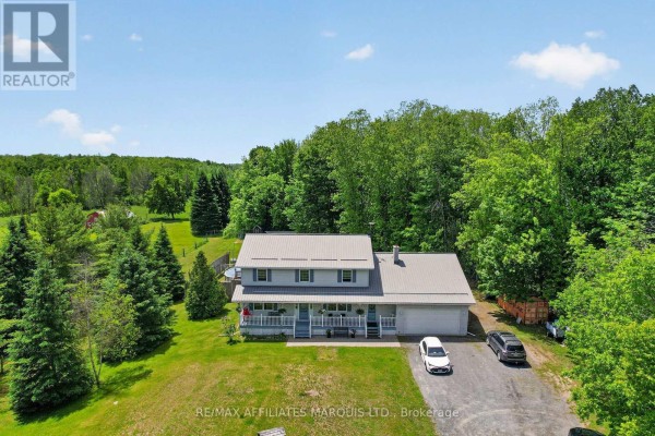 Aerial view of a wooden deck with patio furniture and a round above-ground swimming pool in a fenced yard. - 4720 O'keefe Road, South Stormont