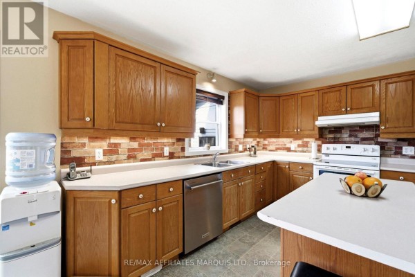 Kitchen with wood cabinets, brick backsplash, white counters and island - 4720 O'keefe Road South Stormont