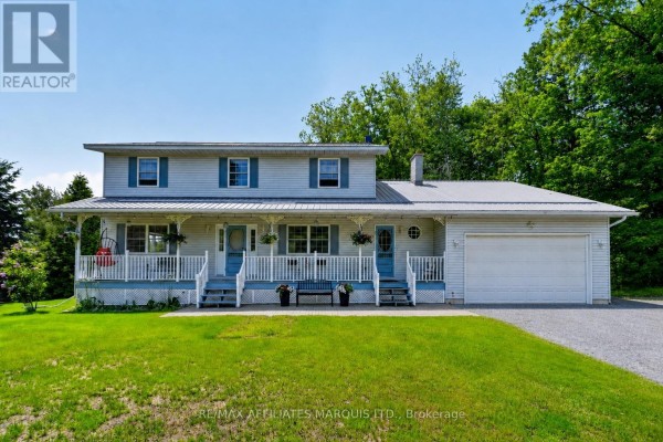 Front exterior of a light blue two-story house with white trim, blue shutters, and a covered wrap-around porch. - 4720 O'keefe Road, South Stormont