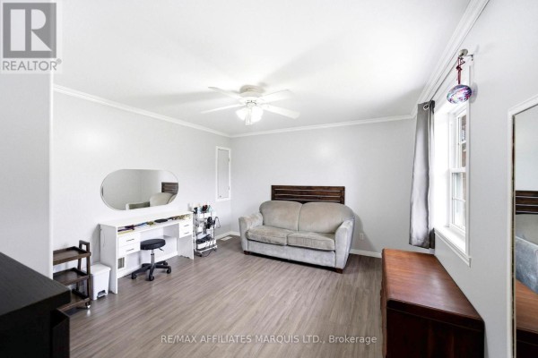 Living room with sofa, desk, mirror, and ceiling fan - 4720 O'keefe Road South Stormont