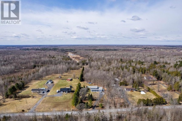 Aerial view of properties with multiple buildings, pool, barn, and woods - 4720 O'keefe Road South Stormont