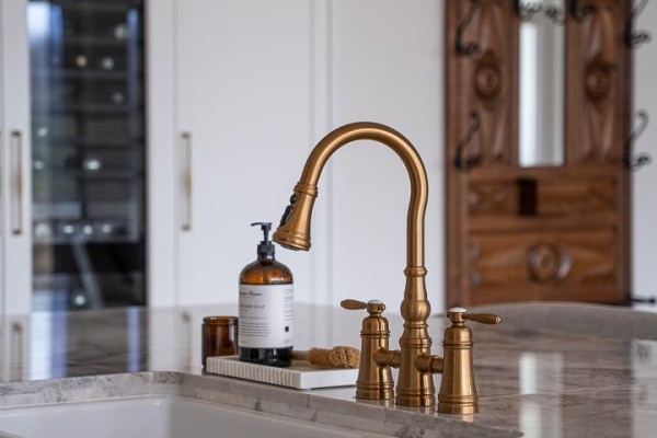 Close-up of a brass kitchen faucet with a marble countertop and soap dispenser. - 472715 Southgate 47 Side Road, Southgate