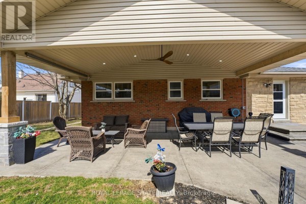 Single-story brick home with stone facade, paved driveway, and garden beds - 473 Mohawk Road W Hamilton