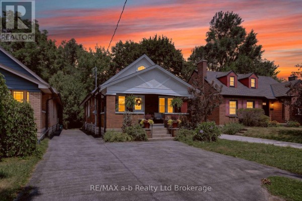 Evening exterior of a brick house with lights on, against a vibrant sunset sky. - 474 Cheapside Street, London East