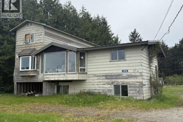 A small wooden building with two windows and wood siding sits in a grassy field. - 474 Copper Bay Road, Skidegate/sandspit