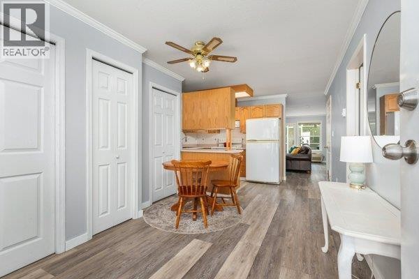 Interior view showing entryway, dining area, and open kitchen with white appliances. - 4740 20 Street Unit# 33, Vernon