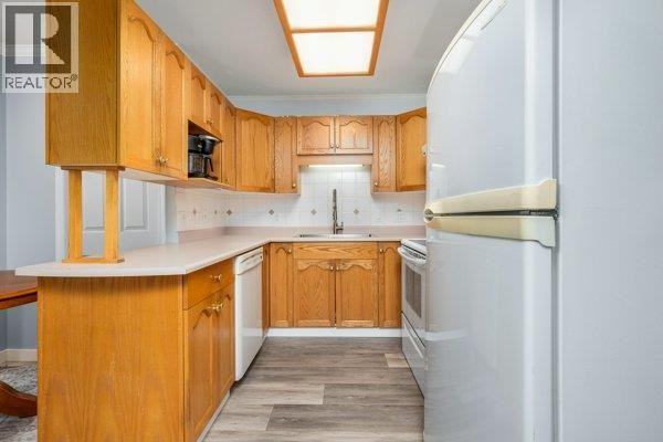 Kitchen with light wood cabinets, white countertops, and a white refrigerator. - 4740 20 Street Unit# 33, Vernon