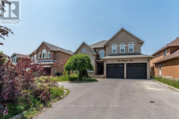 Front exterior of a two-story brick house with a double garage, a mature tree, and landscaping. - 4742 Creditview Road, Mississauga