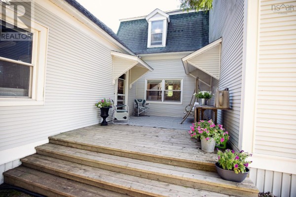 Hallway with wood floors, antique buffet, and doorway leading to a kitchen. - 4747 Canaan Road, Southampton