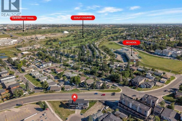 Aerial view illustrating the duplex's proximity to Deerfoot Trail, a golf course, and a school. - 475 34 Avenue Ne, Calgary