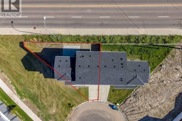 Top-down aerial view of the duplex and driveway, outlining property boundaries. - 475 34 Avenue Ne, Calgary