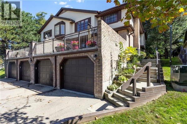 Side view of the townhouse showing a wooden staircase leading up to the main entrance. - 475 Beechwood Drive Unit# 4, Waterloo