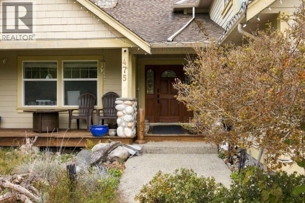 Close-up of the front porch with a wooden door and stone pillar. - 475 Harry Road, Gibsons