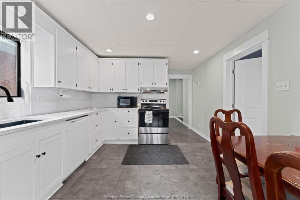 Renovated kitchen with white cabinets, subway tile backsplash, and stainless steel appliances - 475 Mckay Avenue Windsor
