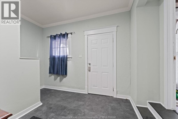Brick fireplace with TV, bar area, and futon couch - 475 Mckay Avenue Windsor