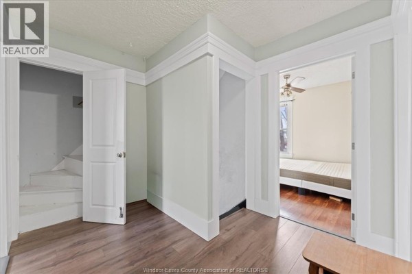 Renovated kitchen with white cabinets, subway tile backsplash, stainless steel fridge, and dining area - 475 Mckay Avenue Windsor