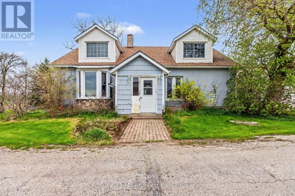 Exterior view of a house with a sunroom and green lawn. - 4758 Bruce 3 Road, Arran Elderslie