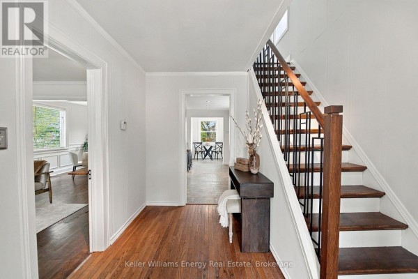 Interior entryway with hardwood floors, white walls, a staircase, and a console table. - 477 Cubert Street, Oshawa
