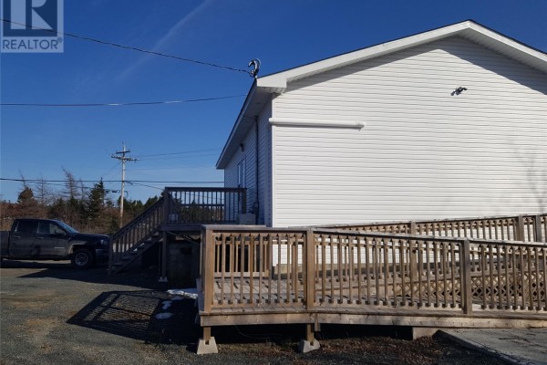 Utility area with a sink, water cooler, shelving, and cleaning supplies. - 478 Main Street, Whitbourne