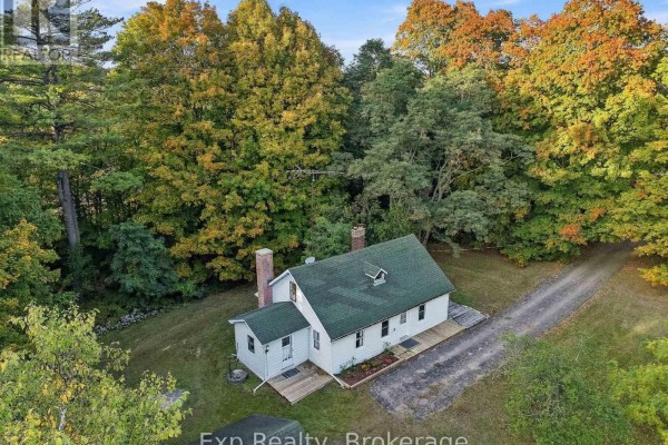 Aerial view of a white house with a green roof and two chimneys, surrounded by trees. - 478 Trottman Road, Cramahe